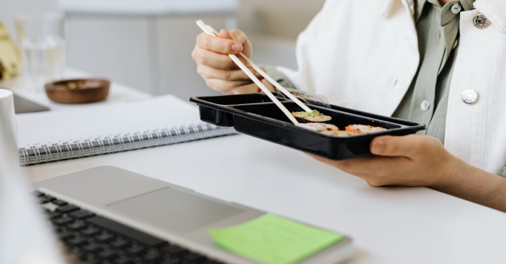 弁当を食べながら昼休みを過ごす人物