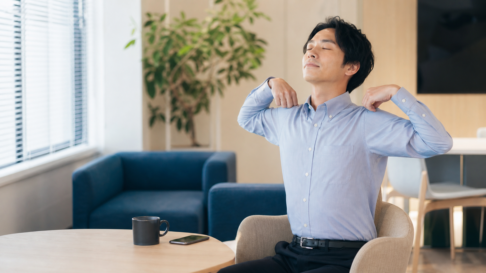 職場ストレスを感じた会社員が休憩室で肩を伸ばして深呼吸する画像