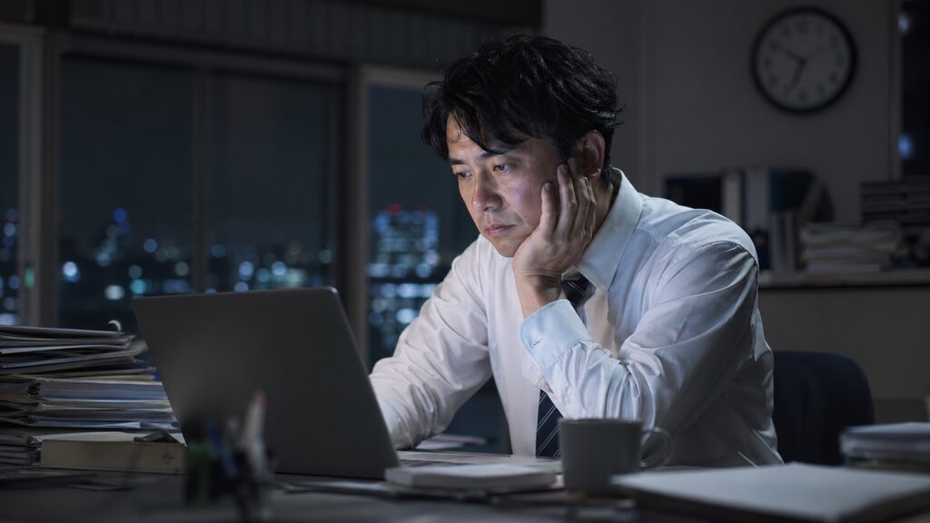 残業50時間は甘えではないと伝える夜のオフィスで疲れた会社員