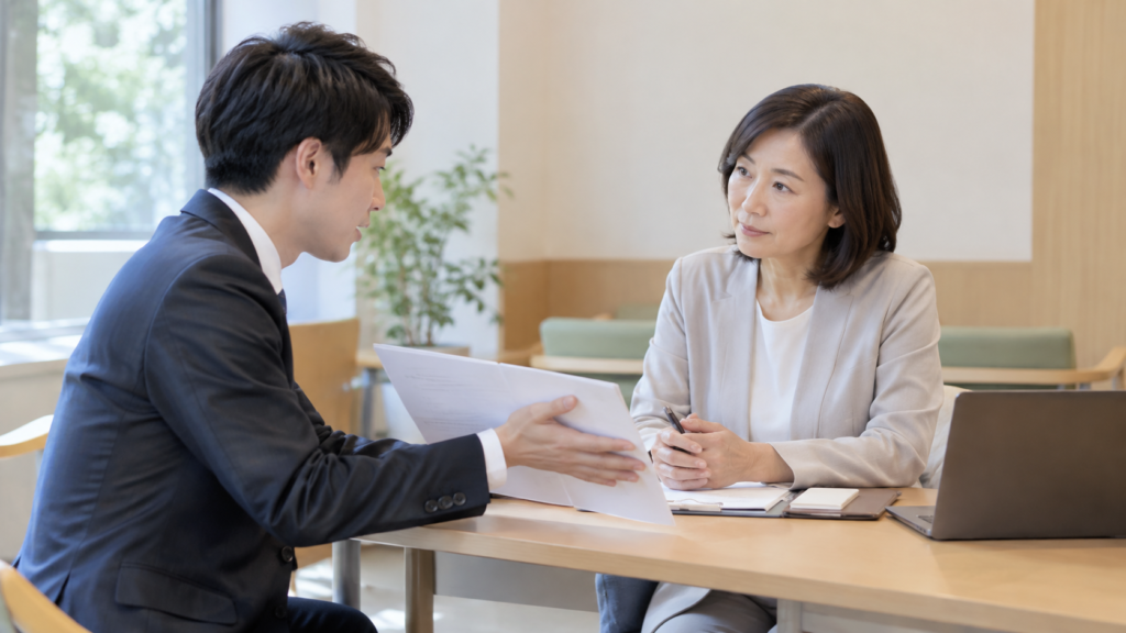 公的な相談窓口で資料を見せながら話す社員