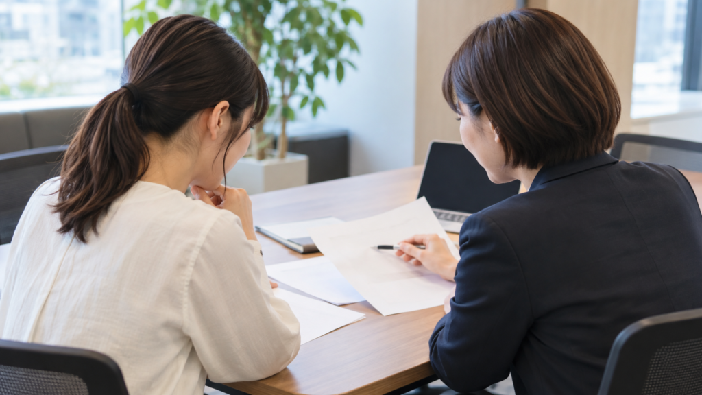会社の人事担当者と育児休業給付金の申請書類を確認する社員