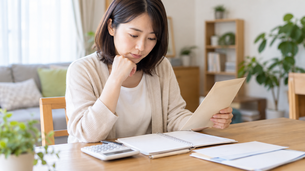 家計ノートと電卓で納付予定を確認する様子