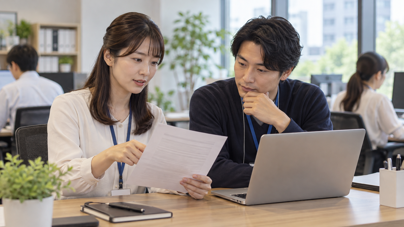 会社のパソコンの利用ルールを担当者と確認する会社員